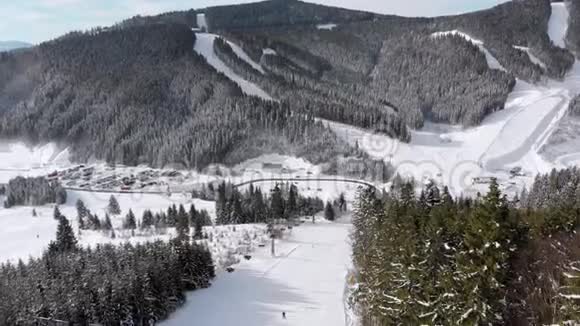 滑雪者在滑雪胜地滑雪升降机附近的高空俯瞰滑雪斜坡Bukvel视频的预览图
