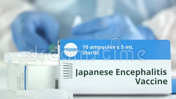 桌子上放着日本脑炎疫苗的盒子对着模糊的实验室助理小说制药标志视频的预览图