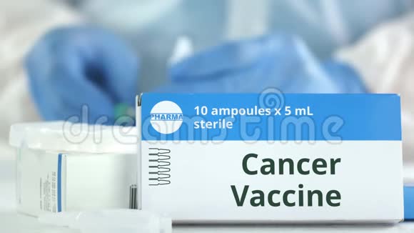 桌子上放着癌症疫苗的盒子对着模糊的实验室助理小说制药标志视频的预览图