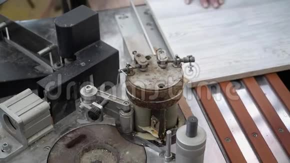 木匠在一台特殊的机器上粘上了木板的一部分特写镜头视频的预览图