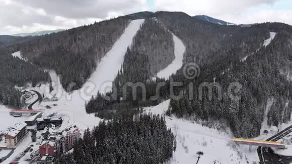 在滑雪胜地设有滑雪者的空中滑雪斜坡雪山森林Bukvel视频的预览图