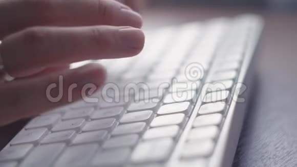 女性手写在白色键盘上从右侧关闭视频的预览图