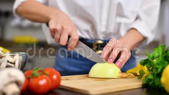 女人用菜刀在木板上切洋葱视频的预览图