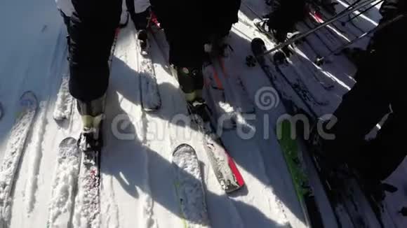 滑雪者和滑雪板上的人群在通往滑雪电梯的通道附近拥挤视频的预览图