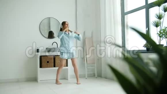 戴耳机的搞笑女孩在浴室用牙刷唱歌戴着耳机视频的预览图