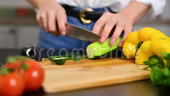 女人慢慢地在厨房的切板上切黄瓜视频的预览图