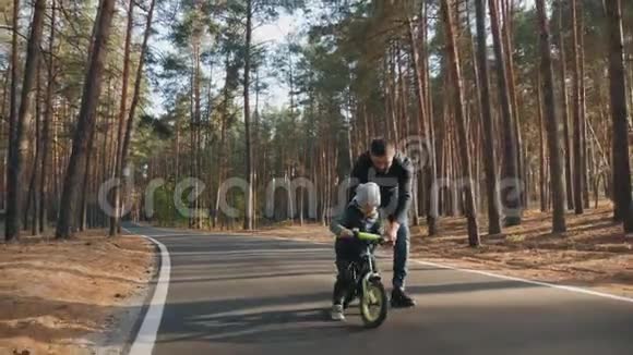 父亲教小儿子骑平衡自行车视频的预览图