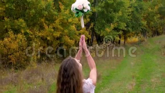 新娘在秋天的公园里扔传统的花束关门视频的预览图