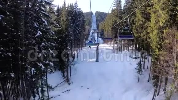 从滑雪椅电梯从松树林和滑雪者上升到索道视频的预览图