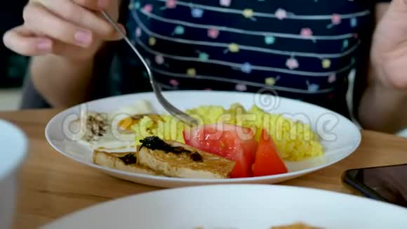 无法辨认的雌性用叉子吃姜黄米饭视频的预览图