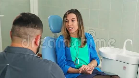 在牙科椅上咨询牙医的女性病人视频的预览图