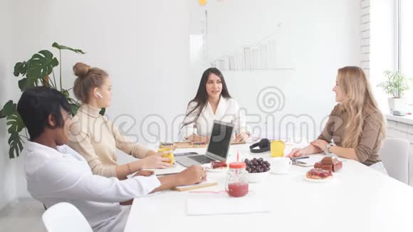 年轻的商务女士在白色办公室的商务会议上在咖啡休息时与人互动视频的预览图