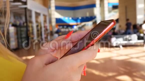 女在机场用红色智能手机发短信视频的预览图