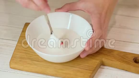 女人在白色的碗里用红色的糖霜视频的预览图