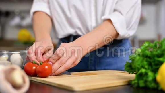 女人慢慢地在厨房的切板上切西红柿视频的预览图