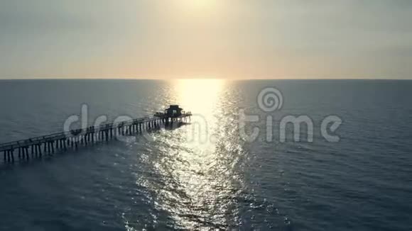 日落于海洋或海洋无人机在码头上空飞行视频的预览图