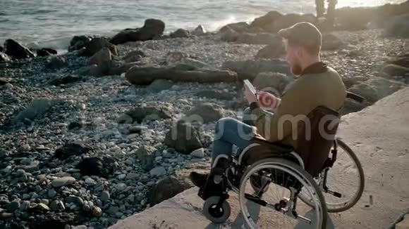 在海边放松时残疾人可以在手机上上网视频的预览图