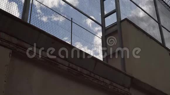 高高的监狱栅栏铁丝网顶着蓝天摄像机慢慢升起视频的预览图