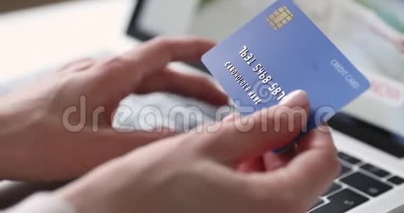 持有笔记本电脑在线支付信用卡的女性客户特写视频的预览图