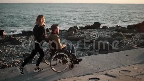 残疾男朋友在海边散步的女孩视频的预览图
