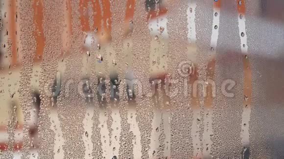 扭曲的窗户玻璃水滴落下来模糊的建筑物在背景视频的预览图