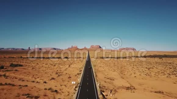 在亚利桑那州和犹他州的纪念碑谷Drun沿着著名的阳光明媚的美国沙漠公路行驶沿着银色的汽车行驶视频的预览图