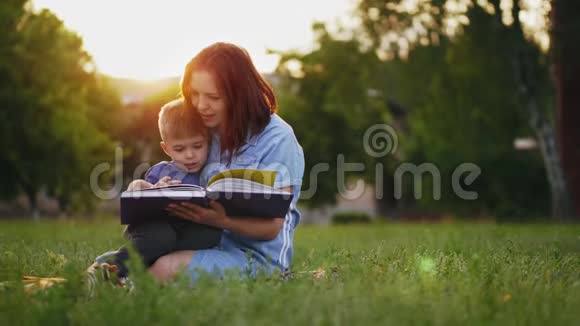 母亲和儿子正在公园看书视频的预览图