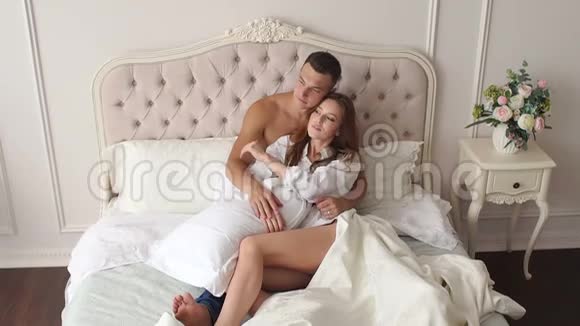 一男一女早上躺在毯子下躺在床上的特写镜头视频的预览图