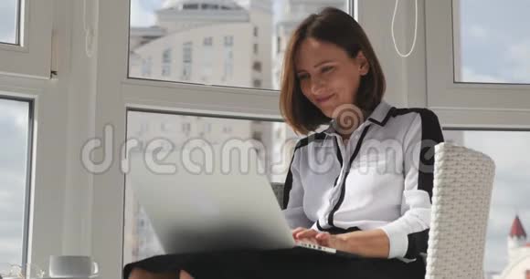年轻的微笑迷人的女商人在笔记本电脑上工作对她成功的工作感到高兴完成了她的工作鼓掌和欢呼视频的预览图