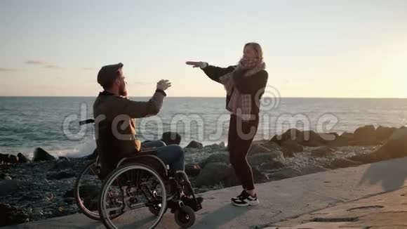 兴高采烈的残疾男女在海堤上嬉戏跳舞视频的预览图