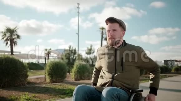 一个自信的大胡子男人在阳光明媚的日子独自坐在轮椅上视频的预览图