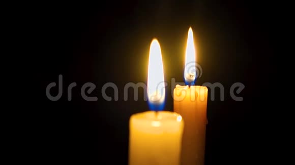 两支蜡烛在黑暗中燃烧教堂里的蜡烛特写镜头视频的预览图