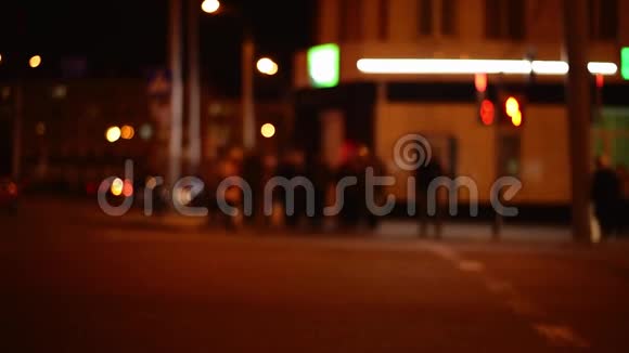 在一个夜间城市一群人在红绿灯处走人行横道视频的预览图