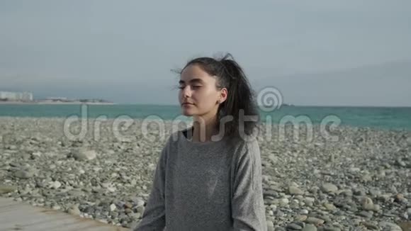 在海滩上实现和平的女人视频的预览图