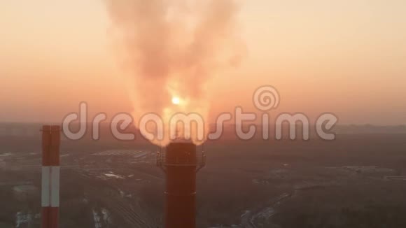 工业烟堆后面的日落空中拍摄视频的预览图