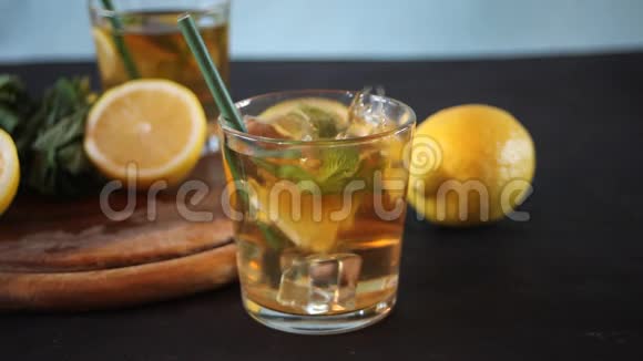 一杯冰和柠檬水果冷茶冰落在玻璃里视频的预览图