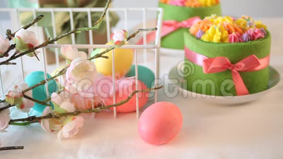 春季复活节节日餐桌背景上有黄油奶油花和五颜六色的鸡蛋的小绿色蛋糕五彩缤纷视频的预览图