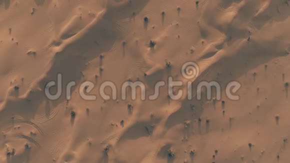 傍晚用汽车轨迹拍摄沙漠沙丘的高空向下拍摄视频的预览图