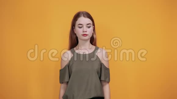 年轻女子的衬衫看上去很悲伤下巴上竖起大拇指视频的预览图