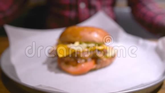 戴手套的白种人吃大的新鲜汉堡视频的预览图