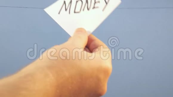 一个男人把一张白纸挂在蓝色的背景上上面印着一笔黑字的钱视频的预览图