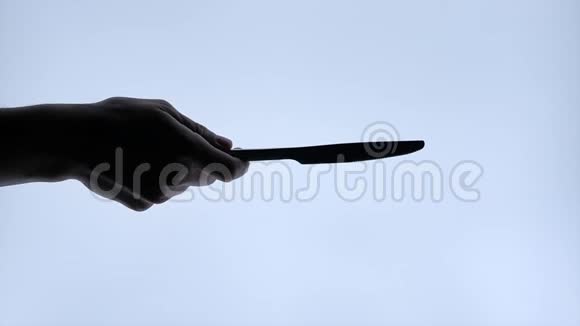 手人扔一把刀黑色的轮廓白色的隔离背景上视频的预览图