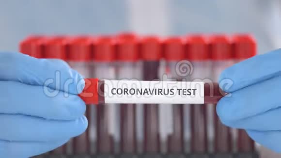 戴防护手套的实验室助理持有冠状病毒测试瓶视频的预览图