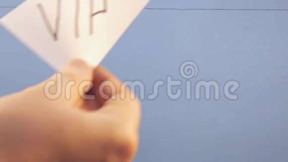 一个男人把一张白纸挂在蓝色背景上上面有一个黑色的铭文贵宾视频的预览图