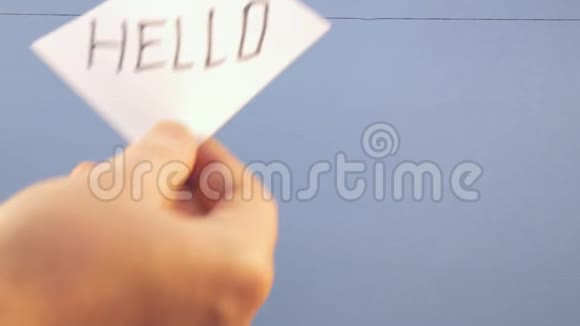 一个男人在蓝色背景上挂着一张白纸上面写着一个黑色的字视频的预览图