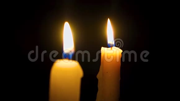 两支蜡烛在黑暗中燃烧教堂里的蜡烛特写镜头视频的预览图