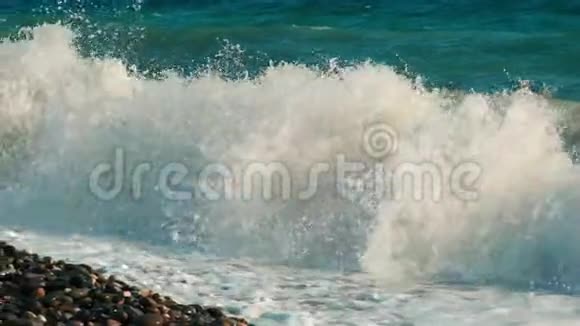 海浪拍打在石滩上湛蓝的海水视频的预览图