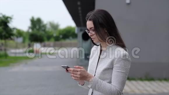 一个穿着商务服和高跟鞋的年轻女人会发出一个快乐的呼唤一个戴着眼镜的女商人在打电话视频的预览图