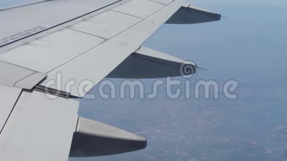 从窗户俯瞰飞机机翼和陆地出口视频的预览图