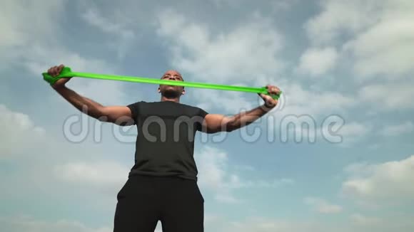 年轻肌肉发达的非洲训练手臂与阻力带视频的预览图